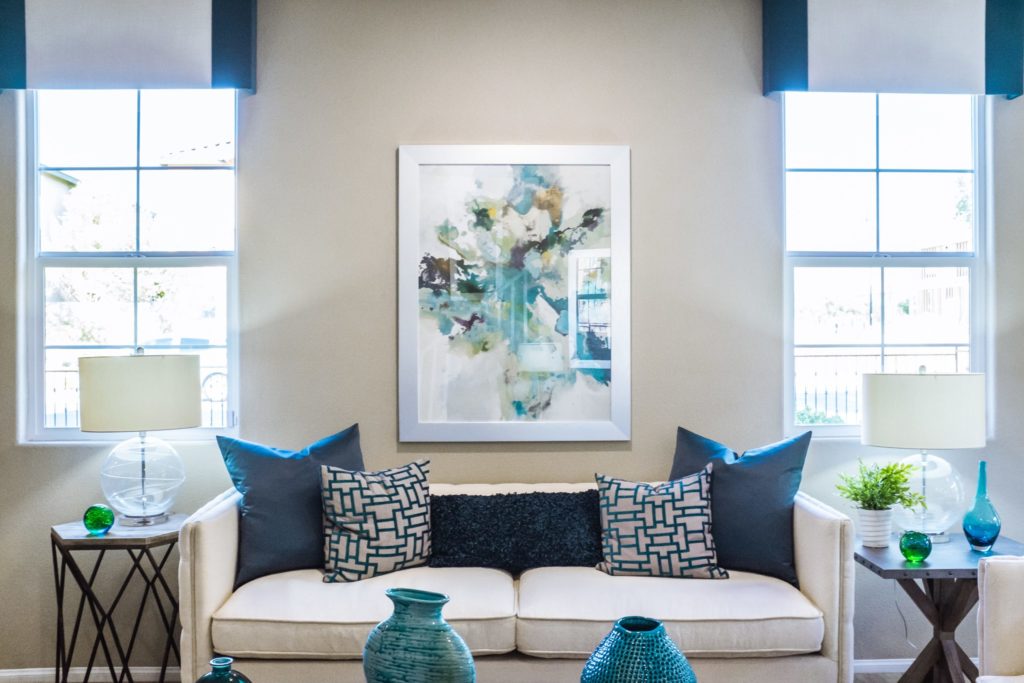 Austin upholstery white sofa in living room with blue throw pillows